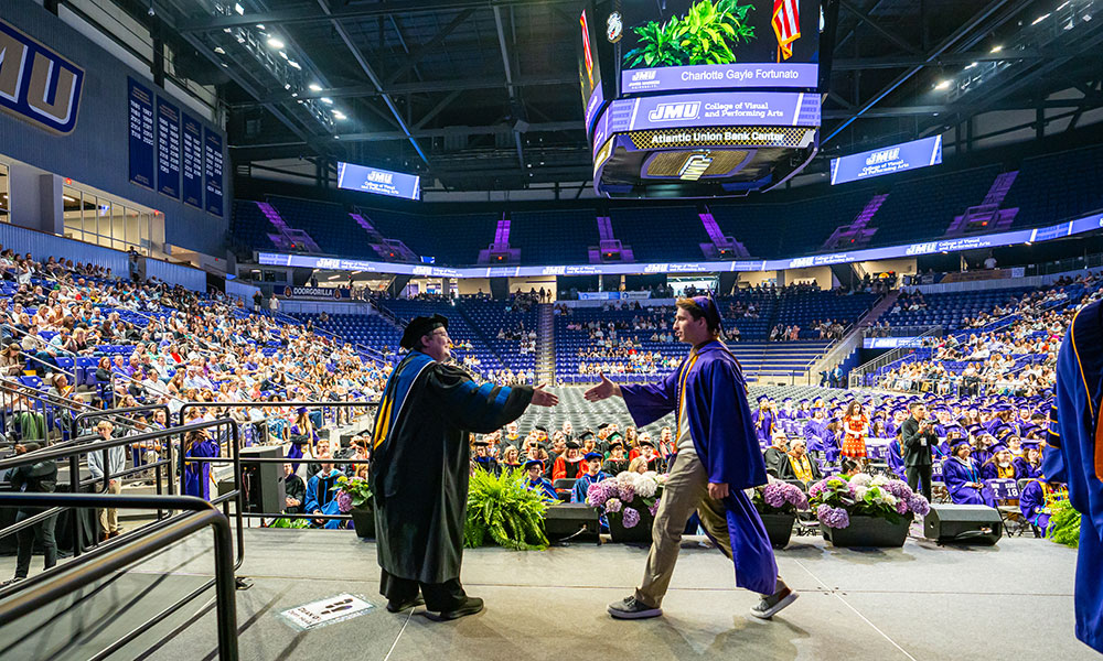 JMU graduation celebration with purple drape and university colors